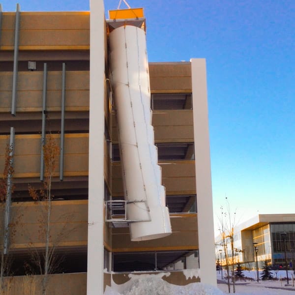 Large Superchute snow chute installed on a parking structure.