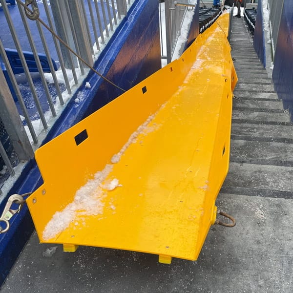 Moving snow from a stadium using a Superchute snow slide.